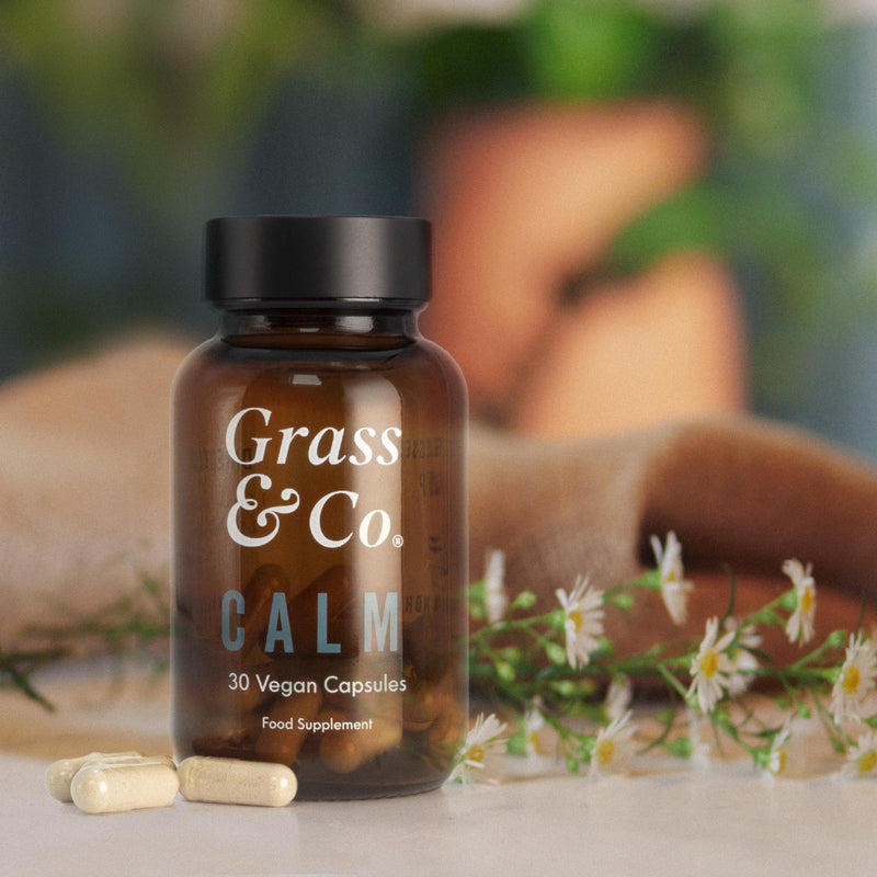 CALM CBD capsules with flowers in the background.